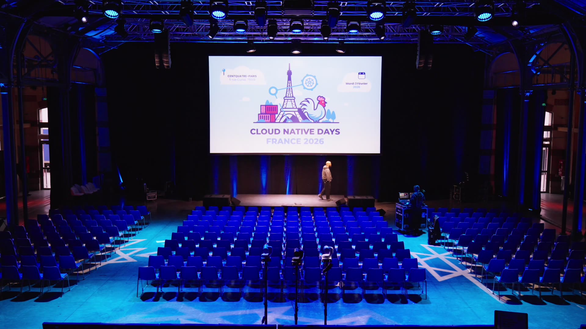 Salle de conférence Cloud Native Days, sièges bleus et grand écran