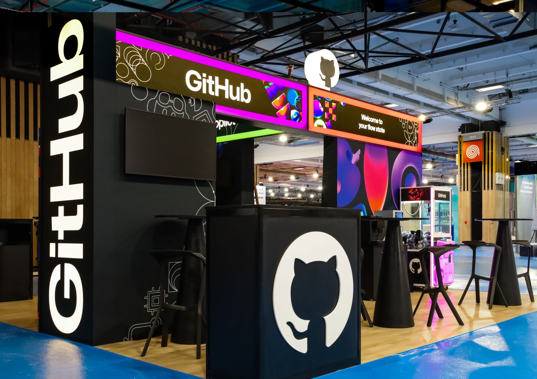Stand GitHub noir, logo lumineux et bandeau néon